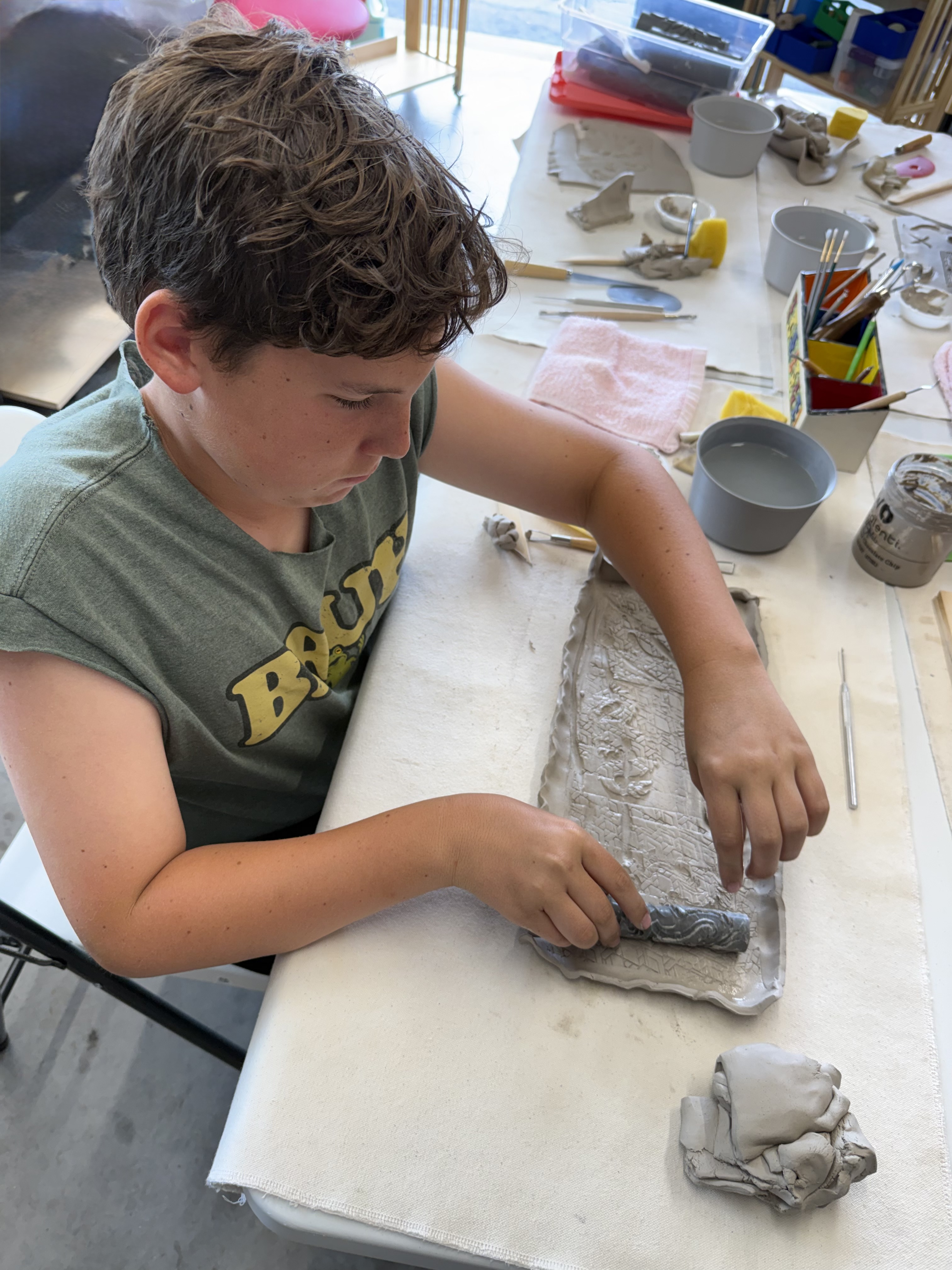Scout creating a clay project at Mud Mojo